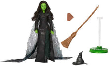 Action figure with black outfit, green gloves, broom, and hat on a white background